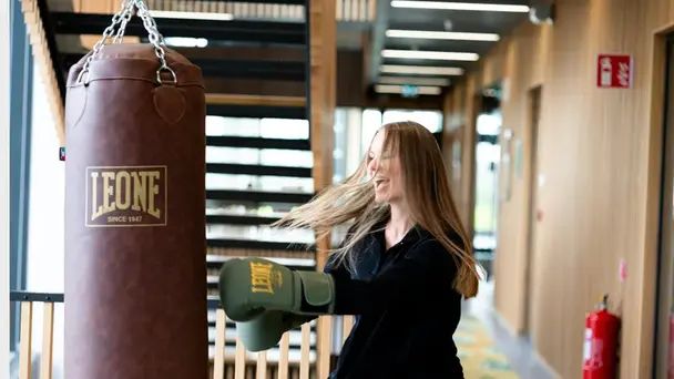 En medarbetare boxar på en boxningssäck på kontoret
