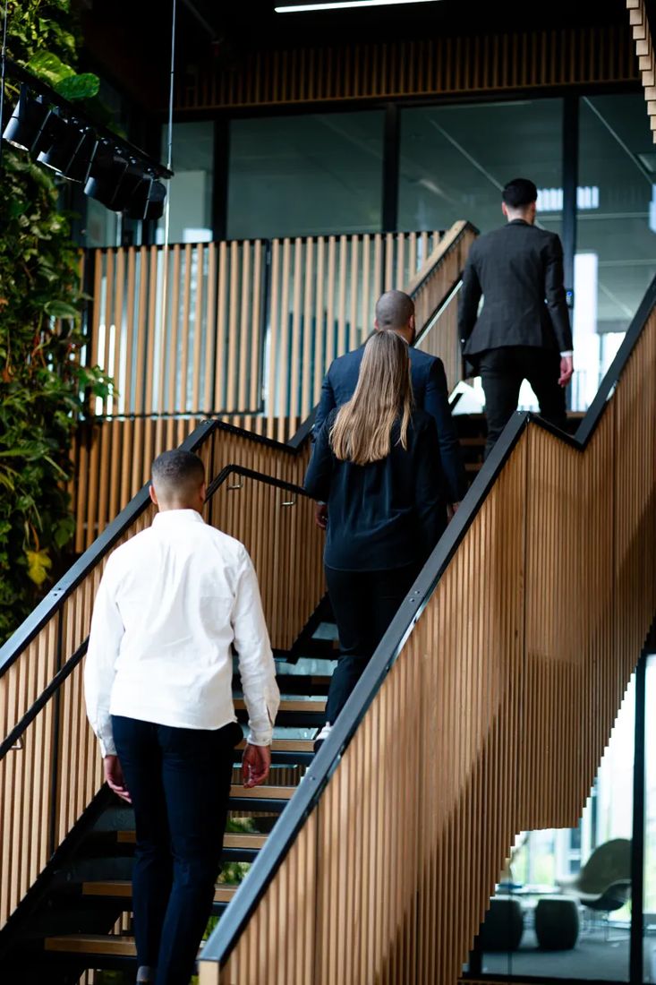 Medarbetare på väg uppför trappan på kontoret